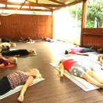 Yoga group relaxing in Shavasana, relaxing after a yoga class on a Yoga Retreat in Crete